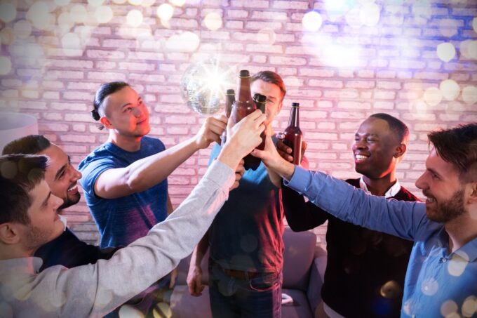 Group Of Multiracial Friend Raising Toast With Beer Bottles