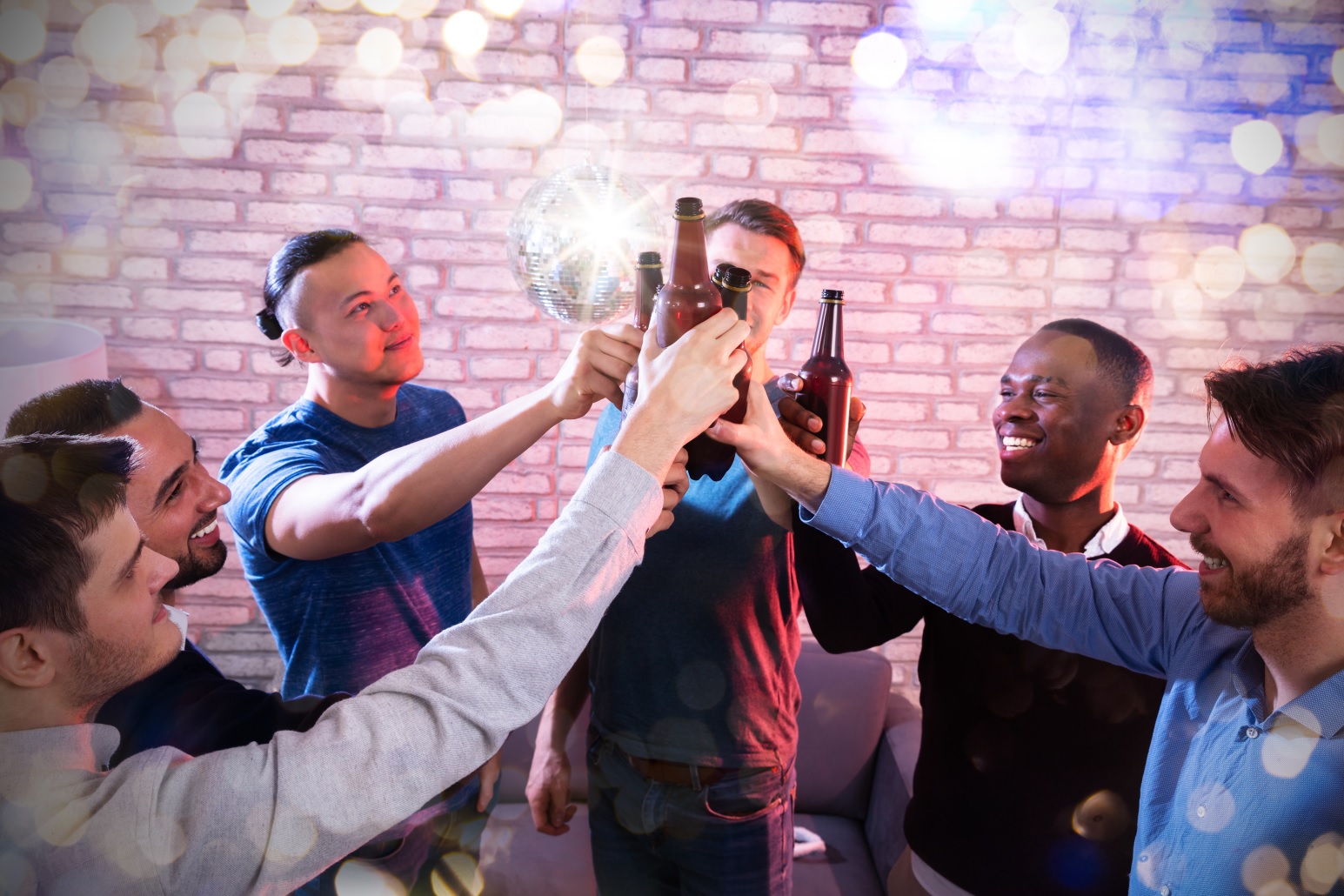 Group Of Multiracial Friend Raising Toast With Beer Bottles